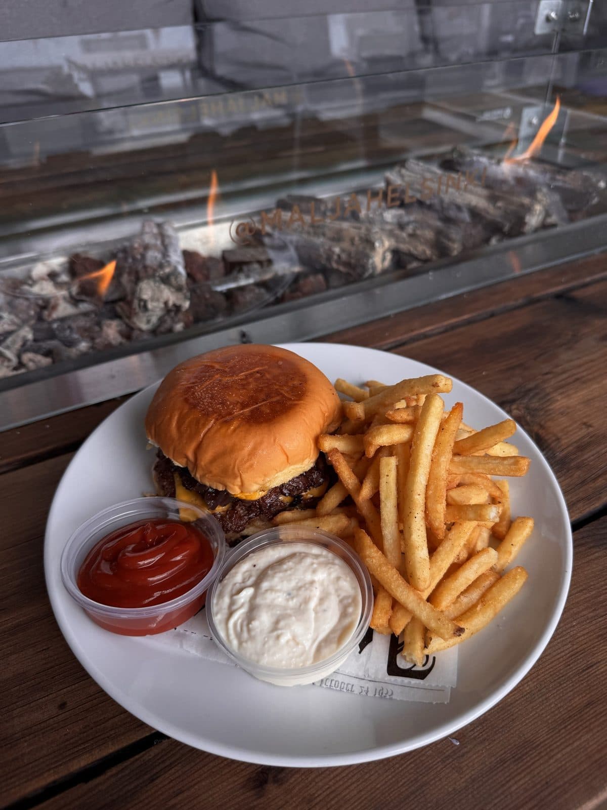 Double smash burger and fries by the fire table